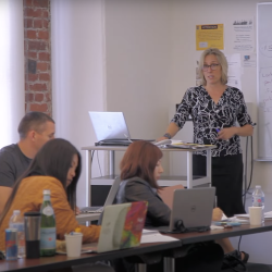 Professor teaching in a classroom of graduate students 